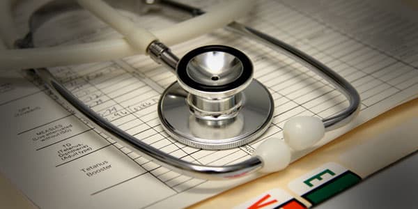 Stethoscope resting on a patient admission chart